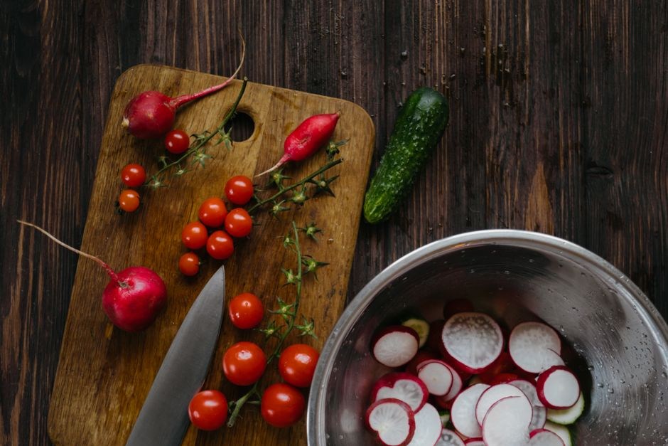 Fresh vegetables arranged on a wooden kitchen table